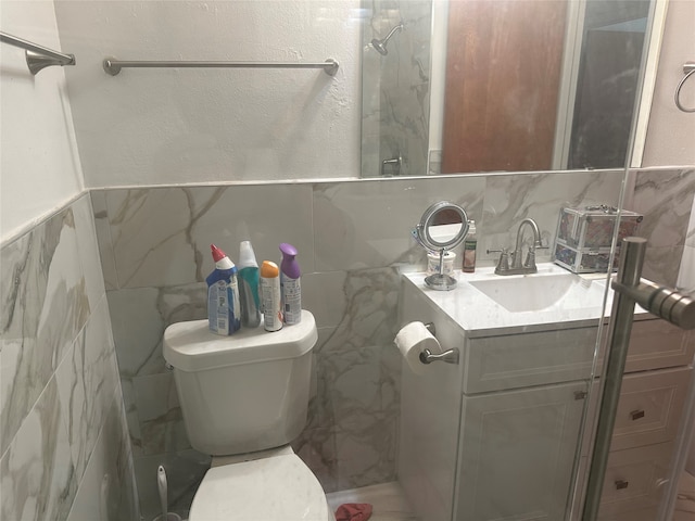 bathroom featuring tile walls, a shower, vanity, and toilet