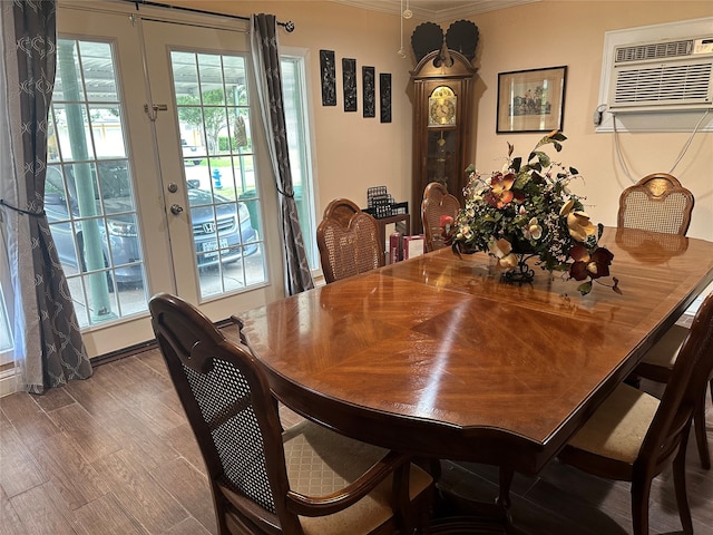 dining area with wood-type flooring, a wall unit AC, french doors, and crown molding