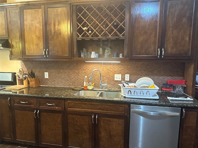 kitchen featuring dishwasher, dark stone counters, backsplash, and sink