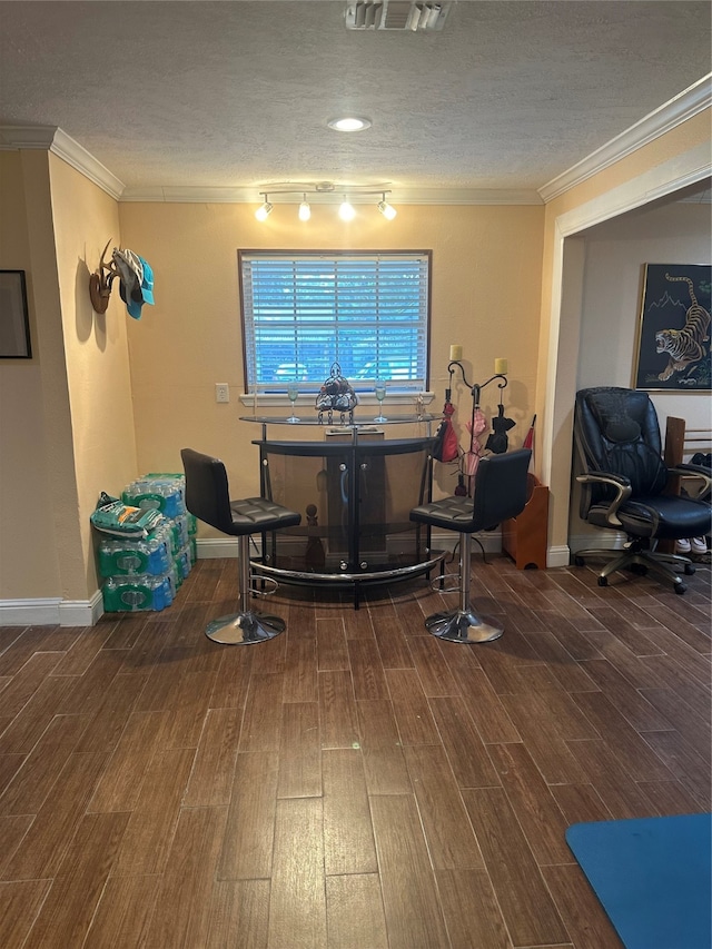 misc room with a textured ceiling, wood-type flooring, and crown molding