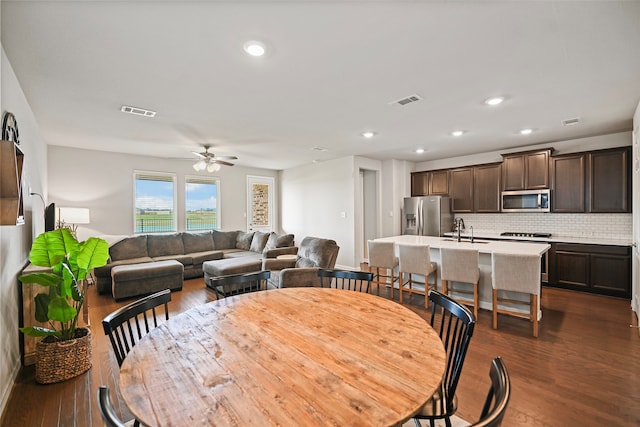 dining area with sink, dark wood-type flooring, and ceiling fan