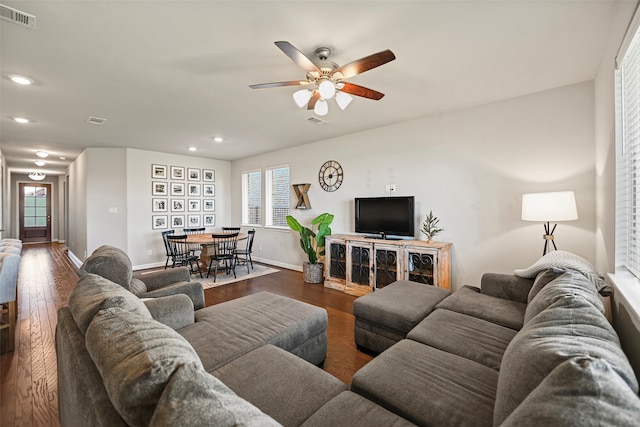 living room with dark wood-type flooring and ceiling fan