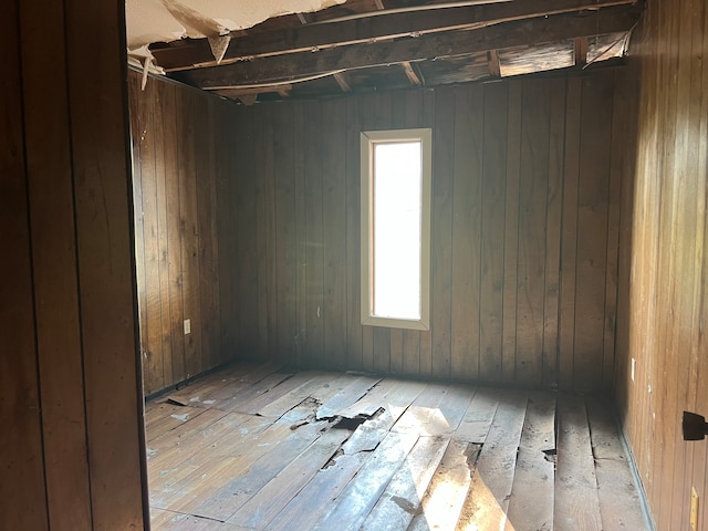 empty room with wooden walls and light wood-type flooring