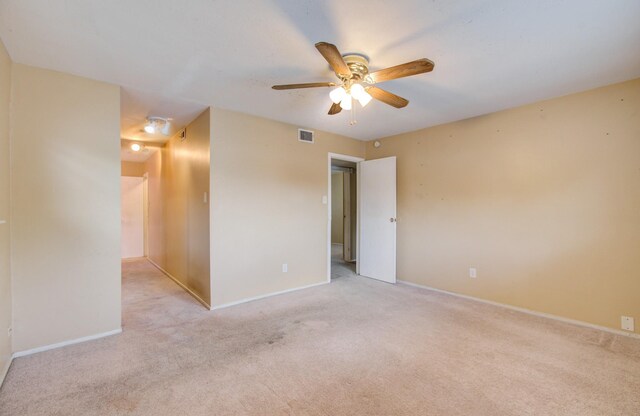 carpeted spare room featuring ceiling fan