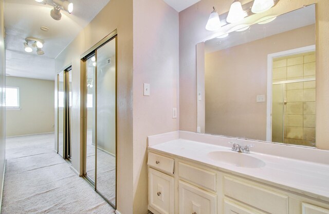 bathroom featuring walk in shower and vanity