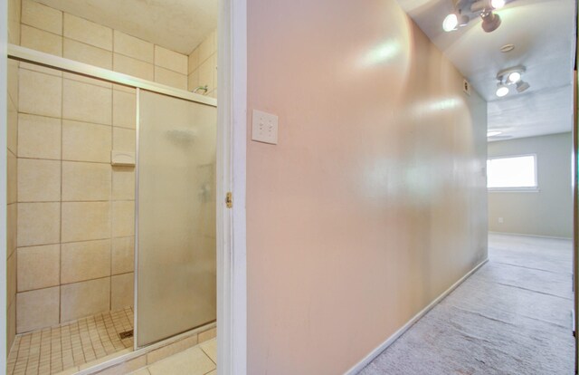 bathroom featuring a shower with door