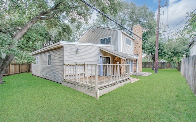 back of property with a deck and a lawn