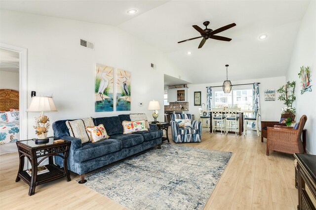 living room featuring ceiling fan, light hardwood / wood-style flooring, and high vaulted ceiling