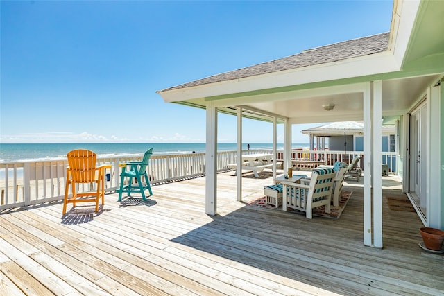 deck featuring a view of the beach and a water view