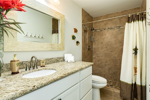 bathroom with a shower with curtain, vanity, tile patterned flooring, and toilet