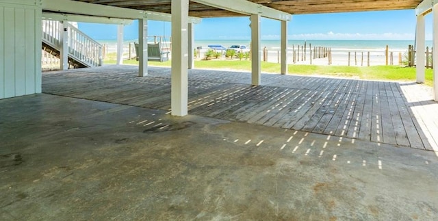 wooden terrace with a view of the beach and a water view