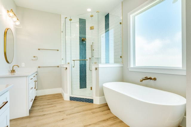 bathroom featuring hardwood / wood-style floors, independent shower and bath, and vanity