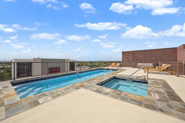 view of pool with a hot tub and a patio