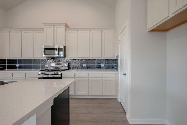 910 Rosewood Trl, Beasley, TX 77417 - kitchen with white cabinetry, tasteful backsplash, appliances with stainless steel finishes, and vaulted ceiling