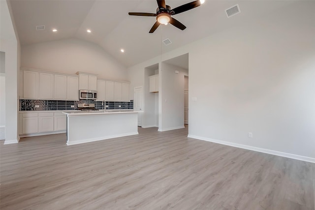 910 Rosewood Trl, Beasley, TX 77417 - kitchen featuring decorative backsplash, light wood-style flooring, stainless steel appliances, and open floor plan