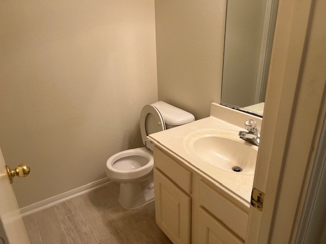 bathroom featuring hardwood / wood-style flooring, vanity, and toilet