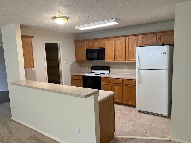 kitchen featuring light tile patterned floors, a textured ceiling, kitchen peninsula, and white appliances