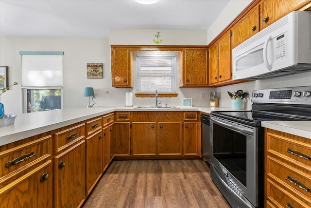 kitchen featuring kitchen peninsula, sink, stainless steel electric range, and dark hardwood / wood-style flooring