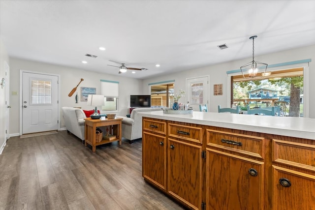 kitchen featuring ceiling fan with notable chandelier, hardwood / wood-style flooring, and decorative light fixtures