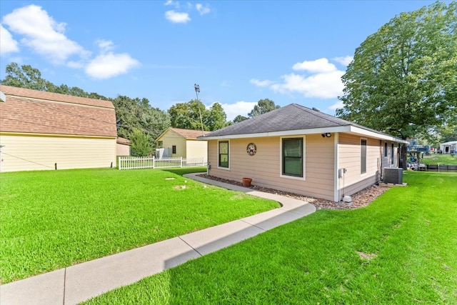 back of property with a lawn and central AC unit