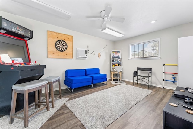 living room with a wall mounted AC, dark hardwood / wood-style floors, and ceiling fan