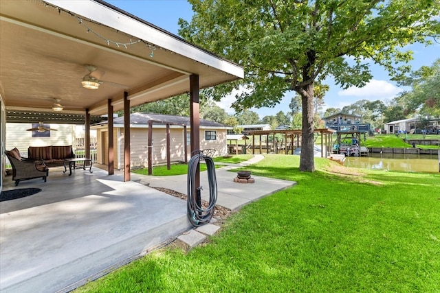 view of yard featuring a patio, a water view, and ceiling fan