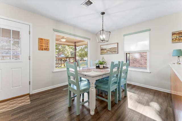 dining area featuring dark hardwood / wood-style floors and a chandelier