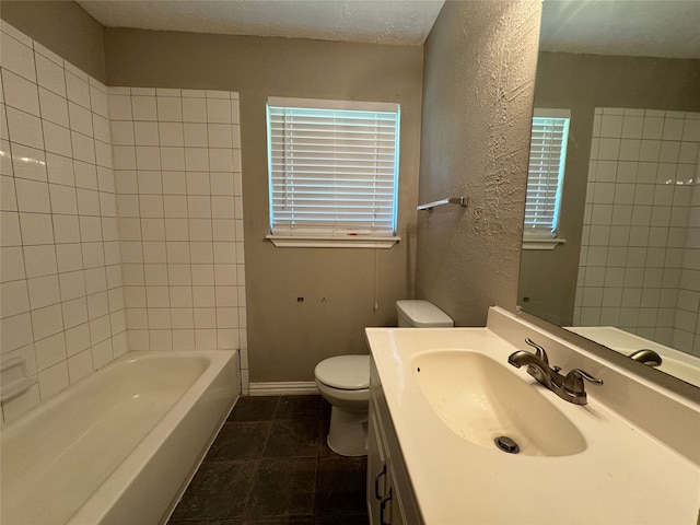 full bathroom featuring vanity, plenty of natural light, toilet, and a textured ceiling