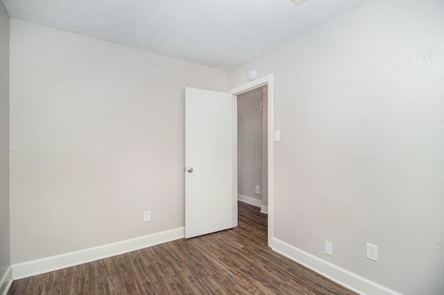 unfurnished room with dark hardwood / wood-style floors