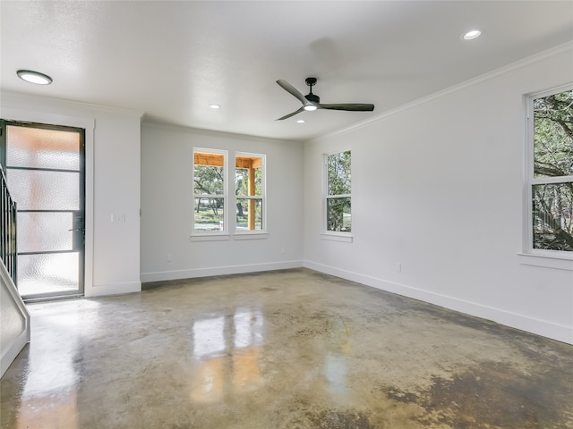 empty room featuring concrete floors, crown molding, ceiling fan, and plenty of natural light