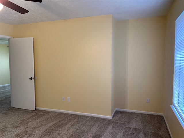 carpeted empty room with a textured ceiling and ceiling fan