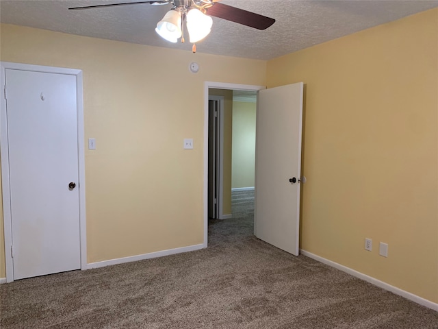 carpeted spare room featuring a textured ceiling and ceiling fan