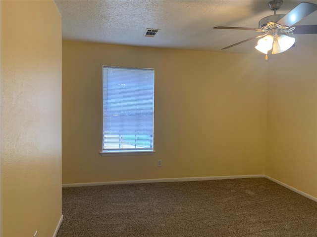 carpeted spare room featuring ceiling fan and a textured ceiling