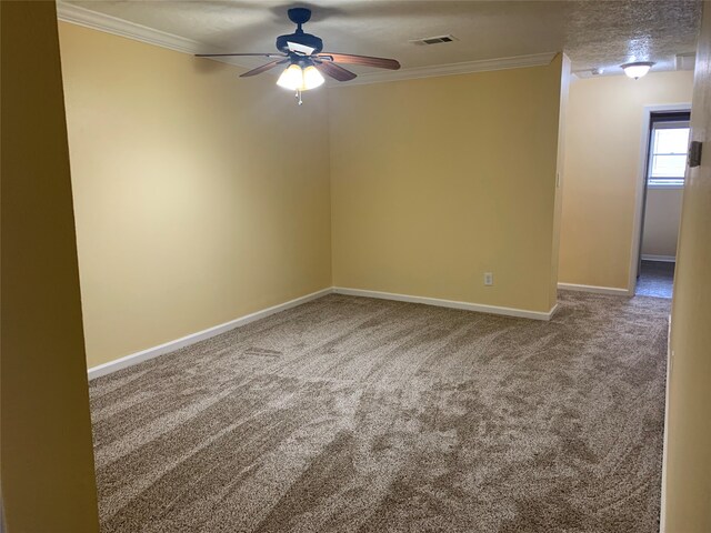 empty room with a textured ceiling, ceiling fan, carpet flooring, and crown molding