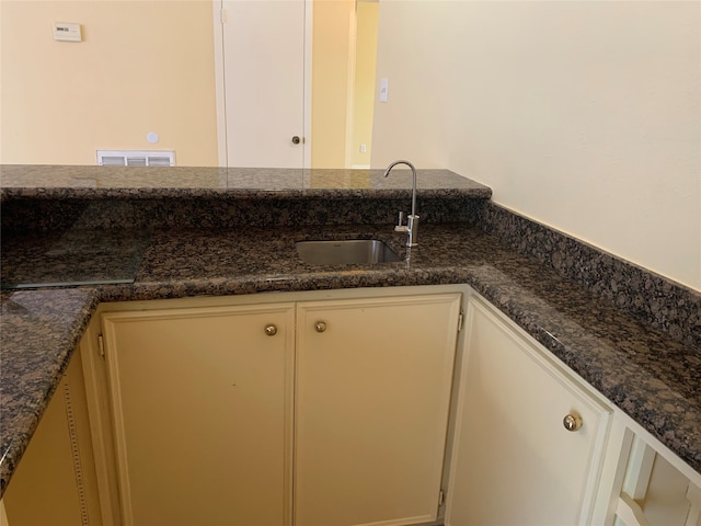 kitchen with dark stone counters and sink