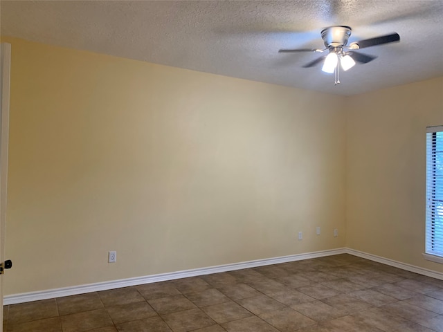 spare room featuring ceiling fan, a textured ceiling, and tile patterned flooring