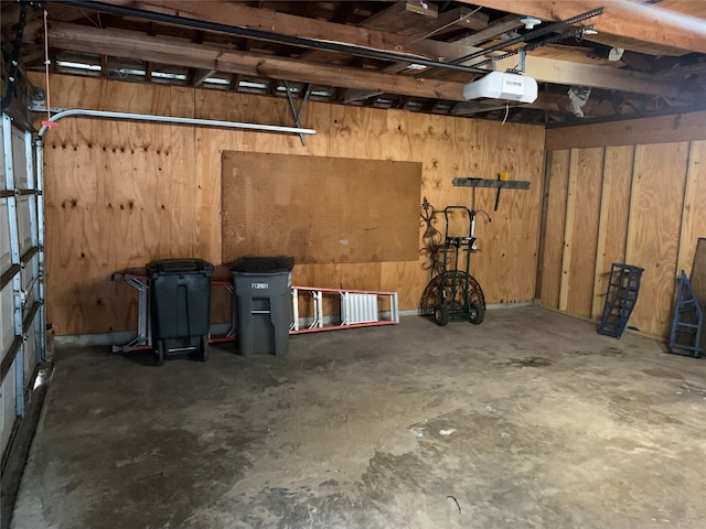 garage featuring a garage door opener and wood walls