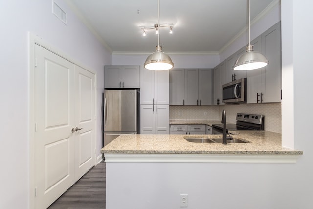 kitchen featuring pendant lighting, light stone counters, appliances with stainless steel finishes, and crown molding