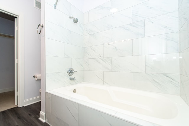 bathroom featuring tiled shower / bath and hardwood / wood-style flooring