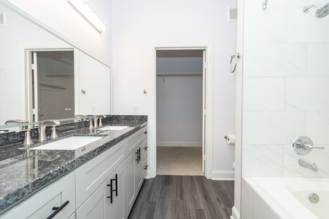 bathroom with plus walk in shower, wood-type flooring, and vanity