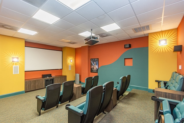 cinema room with a drop ceiling and carpet floors