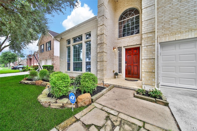 entrance to property with a garage and a yard