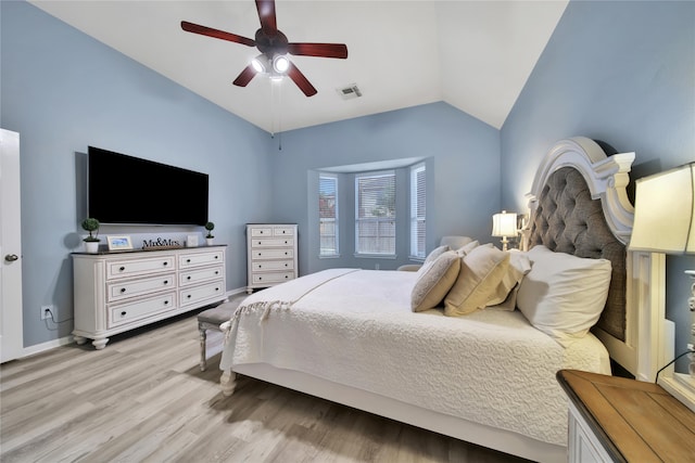 bedroom with light hardwood / wood-style flooring, vaulted ceiling, and ceiling fan