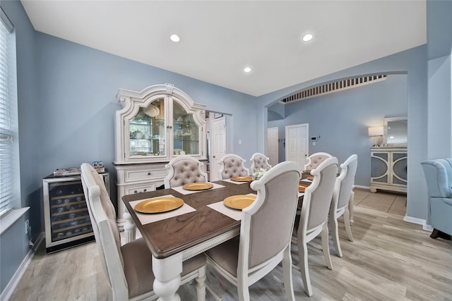 dining area featuring beverage cooler and light hardwood / wood-style flooring