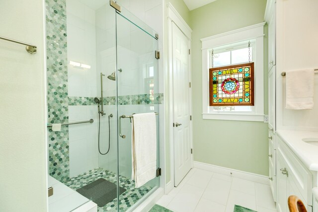 bathroom featuring tile patterned floors, a shower with door, and vanity