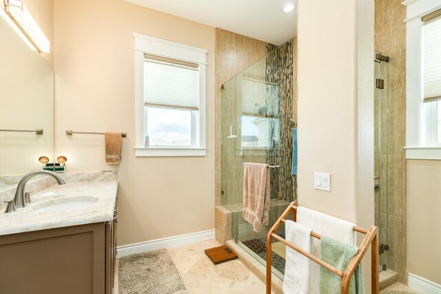 bathroom featuring walk in shower, vanity, and tile patterned flooring