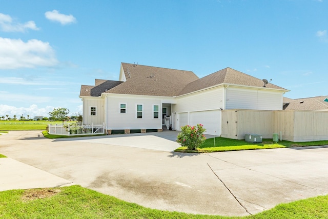 53 Island Psge, Galveston, TX 77554 - rear view of property with roof with shingles, concrete driveway, fence, an attached garage, and a lawn