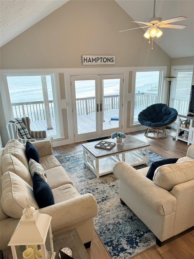 living room featuring high vaulted ceiling, ceiling fan, hardwood / wood-style flooring, and french doors