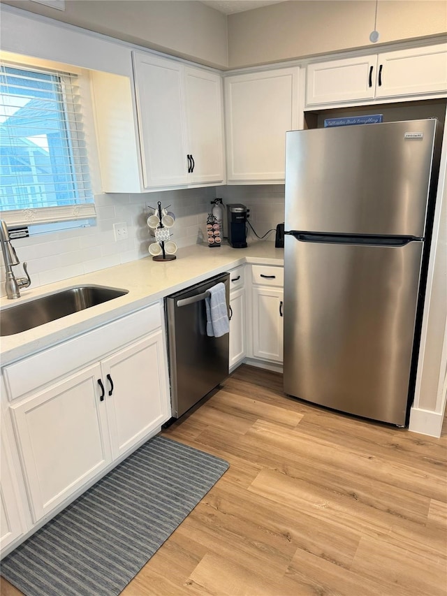 kitchen featuring light wood-type flooring, white cabinetry, appliances with stainless steel finishes, and sink