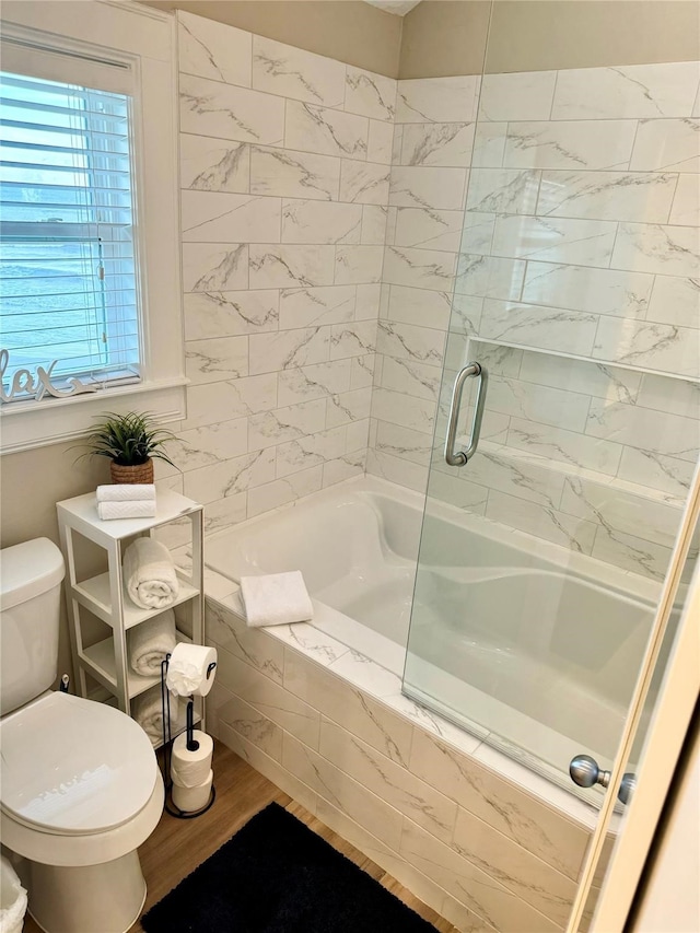 bathroom featuring independent shower and bath, hardwood / wood-style floors, and toilet